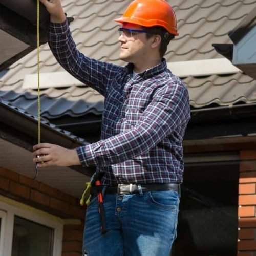 professional-worker-measuring-height-of-roof-with-tape.jpg