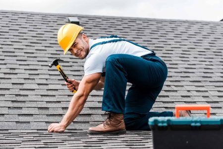 selective-focus-of-handsome-handyman-repairing-roof.jpg